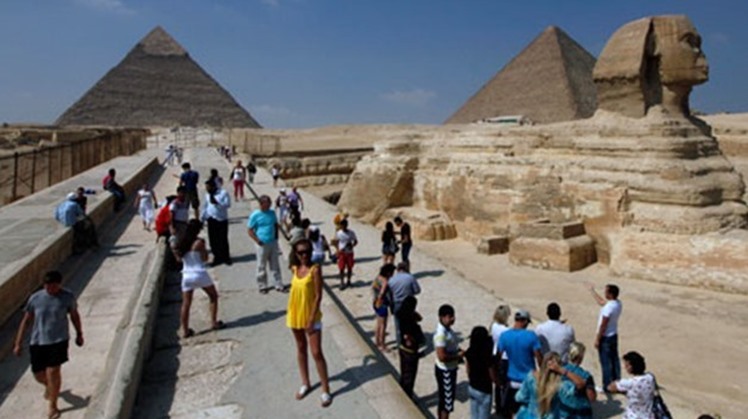 Tourists take pictures at the Sphinx and the Pyramids of Giza in Cairo - Reuters
