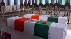 India's Central Reserve Police Force (CRPF) personnel stand behind the coffins of t district on Friday, during a wreath-laying ceremheir two colleagues, who according to police were killed during a gun battle with militants in north Kashmir's Kupwaraony 